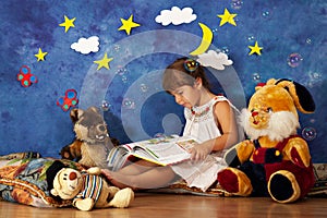 Little girl reading stories to her stuffed toy friends