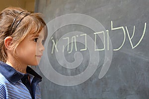 Little girl reads Hello First Grade greetings in Hebrew