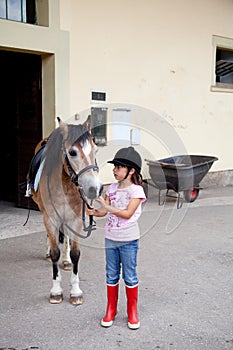 Little girl ready for a horseback riding lesson