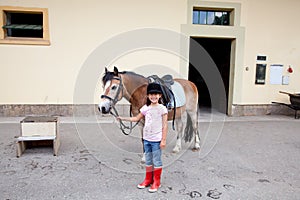 Little girl ready for a horseback riding lesson