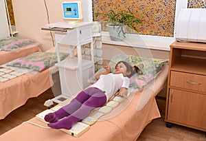The little girl receives procedure of a magnetotherapy. Physioth
