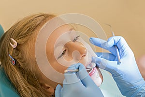 Little girl at the reception in the dentist& x27;s office. little girl sitting in a chair near a dentist after dental treatment.