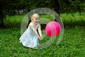 Little girl with red balloon in the forest.