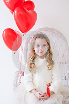 Little girl with red balloons on Valentine`s Day