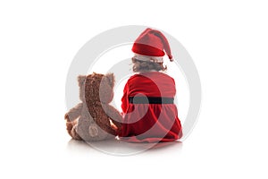 Little girl in red christmas santa hat and teddy bear toyon white background