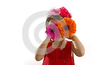 Little girl in red dress with gerbera flowers at her eyes