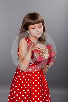 Little girl in red dress holding her present