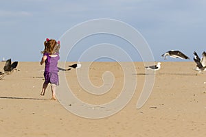 Little girl with red hair chasing birds