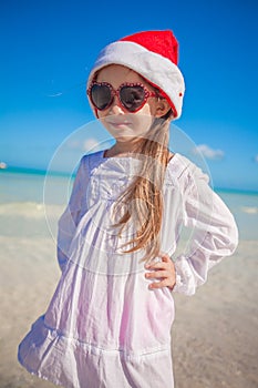 Little girl in red hat santa claus and sunglasses