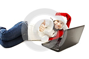 Little girl in red Santa hat with laptop