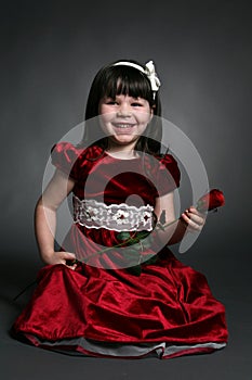 Little girl with red satin dress and a rose