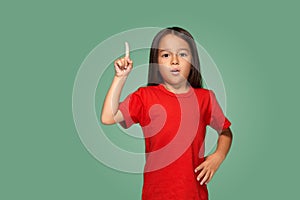 Little girl in red t-shirt with finger up