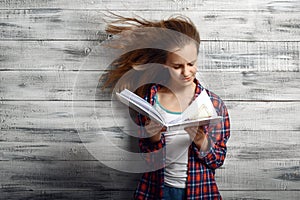 Little girl reding a book against powerful airflow