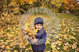 Little girl  rejoices in the colors of autumn.