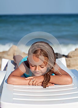 Little girl relaxing on a beach chair