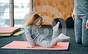 A little girl repeats exercises for her mother