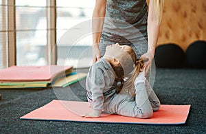 A little girl repeats exercises for her mother