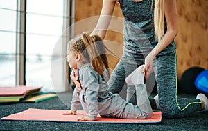 A little girl repeats exercises for her mother