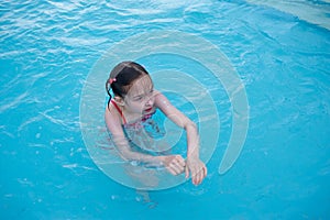 A little girl is resting in the summer in the aqua park. baby swims in the pool