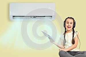 little girl resting under air conditioner on colored wall at home