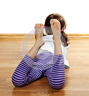 A little girl resting on a wooden floor