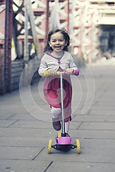 Little girl ridding scooter