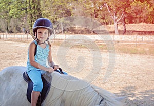 Little girl rider on a white pony.