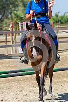 Little girl that rides a brown pony during Pony Game competition at the Equestrian School