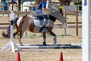 Little girl that rides a brown pony during Pony Game competition at the Equestrian School