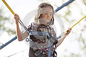 Little girl rides bungee on the playground