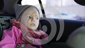 Little girl rides a car in the car seat.