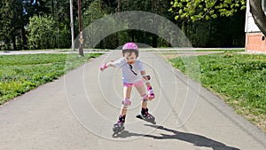 Little girl rides roller skates outdoor