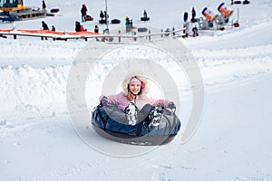 A little girl rides a tubing down a slide