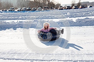 A little girl rides a tubing down a slide