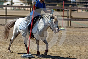 Little girl that rides a white pony during Pony Game competition at the Equestrian School