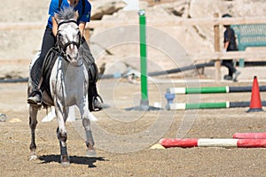 Little girl that rides a white pony during Pony Game competition at the Equestrian School