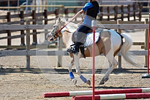 Little girl that rides a white pony during Pony Game competition at the Equestrian School