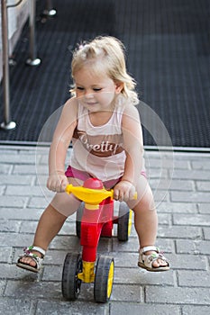 A little girl is riding a balance bike. Fun and entertainment