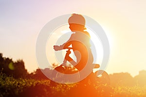 Little girl riding bike at sunset