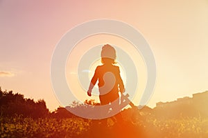 Little girl riding bike at sunset, active kids