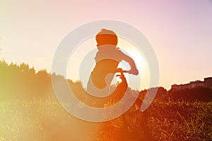 Little girl riding bike at sunset, active kids