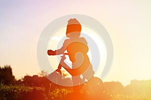 Little girl riding bike at sunset, active kids