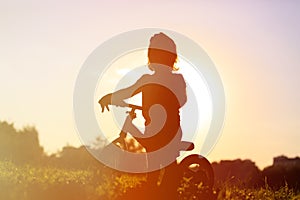 Little girl riding bike at sunset, active kids