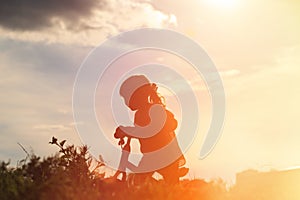 Little girl riding bike at sunset, active kids