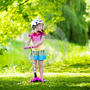 Little girl riding a colorful scooter