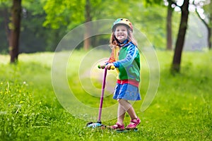 Little girl riding a colorful scooter
