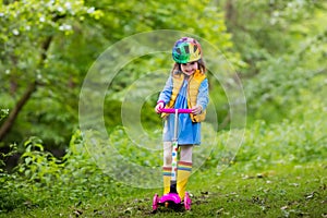 Little girl riding a colorful scooter