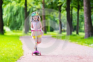 Little girl riding a colorful scooter