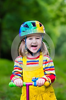 Little girl riding a colorful scooter