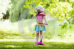 Little girl riding a colorful scooter